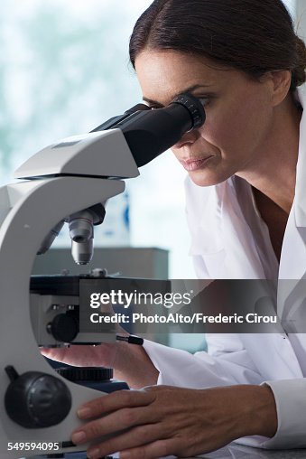 Scientist using microscope in laboratory Scientist using microscope in laboratory