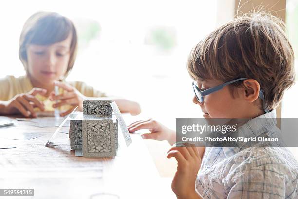 boys building house of cards together - house of cards stock pictures, royalty-free photos & images