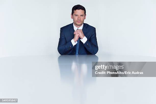 confident businessman seated at table, portrait - completo da uomo foto e immagini stock