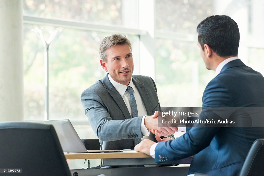 Businessmen shaking hands in meeting