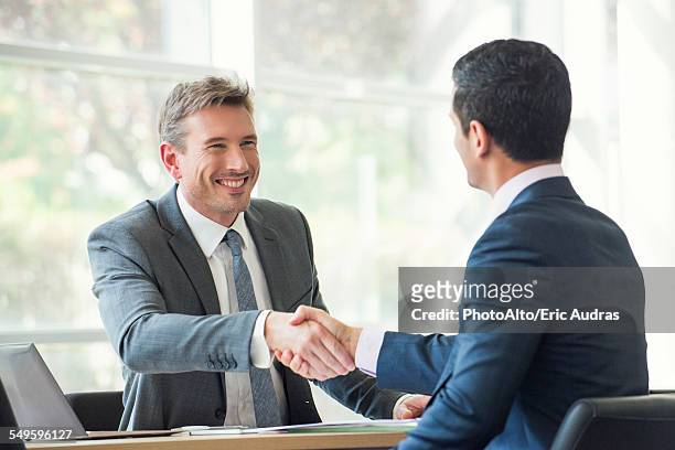 businessmen shaking hands in meeting - bank manager with client stock-fotos und bilder