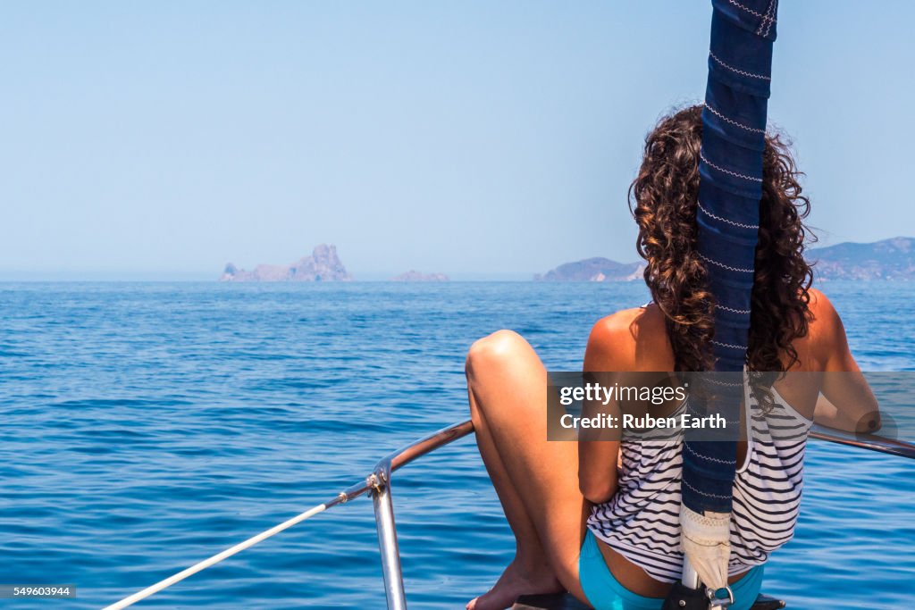Woman on a sailboat arriving to Es Vedra Island