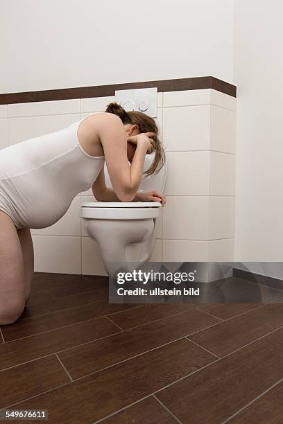 Young pregnant woman, 35 years old, feeling sick on a toilet.