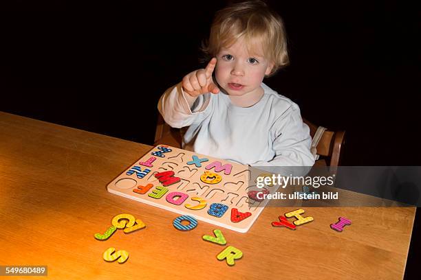 Boy, 2 years old, playing with an ABC puzzle