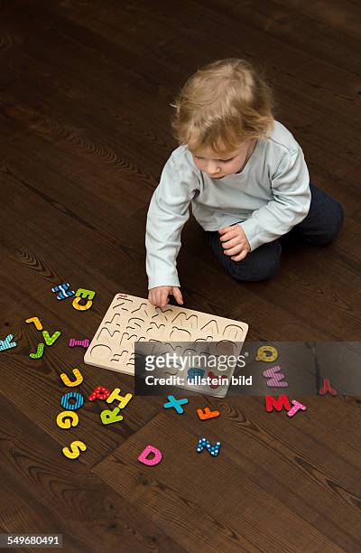 Boy, 2 years old, playing with an ABC puzzle