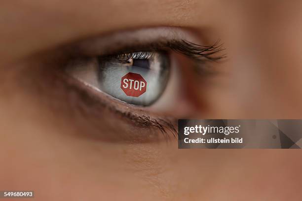 Woman looking at an Internet site with STOP sign. Symbol: protection against cyber crime.