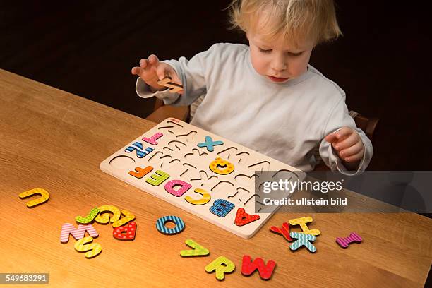 Boy, 2 years old, playing with an ABC puzzle