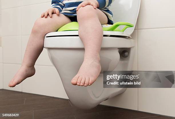 Year old boy with childrens seat on a toilet.