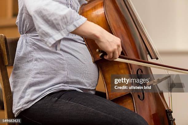 Pregnant woman playing the cello.