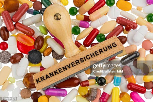 Stempel auf bunten Tabletten, Symbolfoto für Gesundheitskosten, Krankenversicherung und finanzielle Erstattung