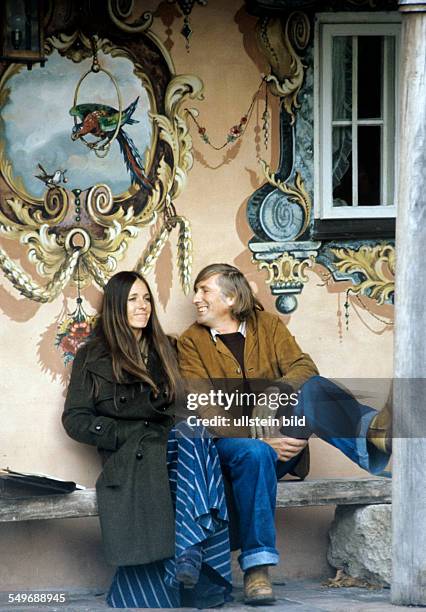 Tomi Ungerer Grafiker, Illustrator, Schriftsteller, und Ehefrau Yvonne vor bayerischem Bauernhaus, Lüftlmalerei