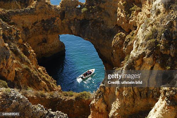 Ponta da Piedale, Grotten, Felsformationen und Toren, das Motorboot verläßt gerade eine der Grotten