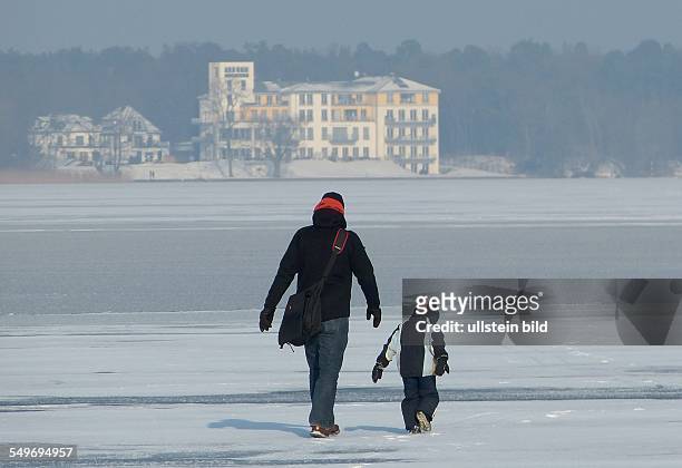 Vorsicht ist geboten - bei einer Eisdicke von ca 5 cm tummeln sich die Berliner auf dem Eis, Mann mit Kleinkind beim Spazierengehen