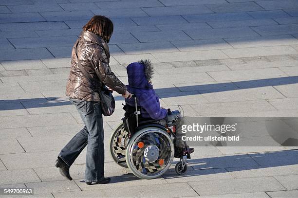 City Köln: Frau im Rollstuhl wird geschoben Köln
