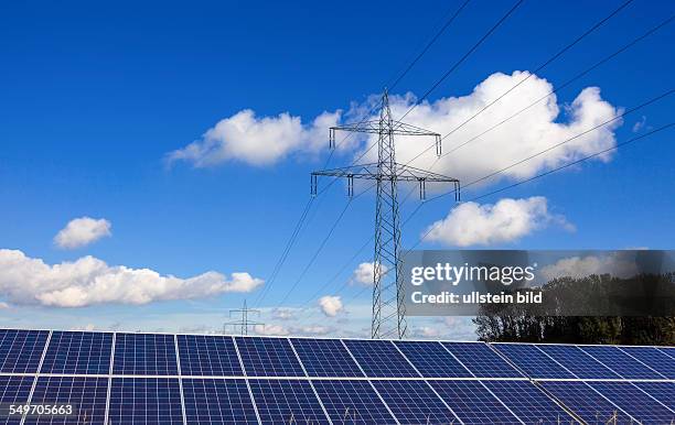 Solarzellen zur Gewinnung von alternativer Sonnenenergie. Im Hintergrund ein Strommast.