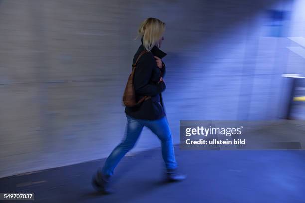Eine junge Frau in einer Unterführung für Fußgänger hat Angst vor Belästigung und Kriminalität