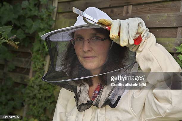 Bienenstock der Kölner Hobby- und Stadtimkerin Claudia Hoch. Hier: Claudia Hoch bei der Bienenpflege in ihrem Hinterhof