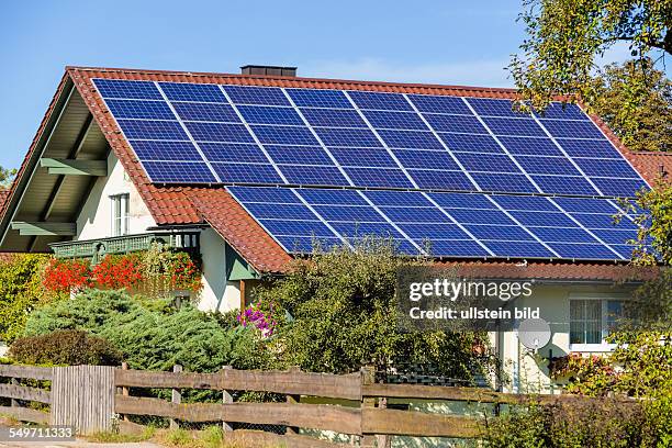 Auf einem Einfamilienhaus werden Solarzellen für alternative Sonnenenergie verwendet