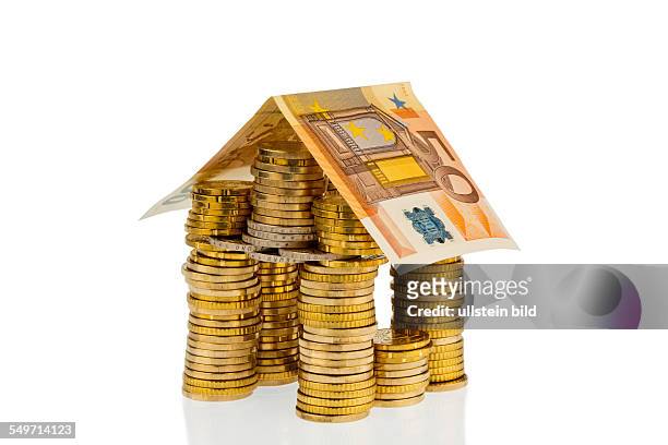 Ein Haus aus Geld Münzen und Geldscheinen. Symbolphoto für Hausbau und Bausparen