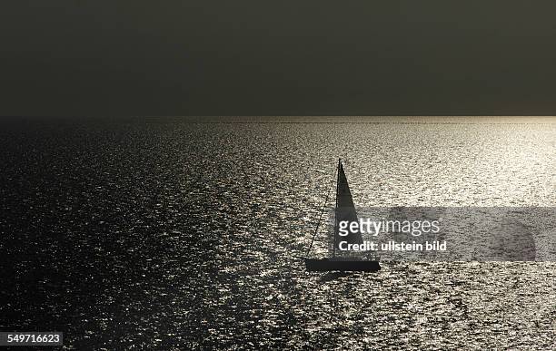 Cap Sani, Greece, a sailboat in the backlight in the Agean Sea