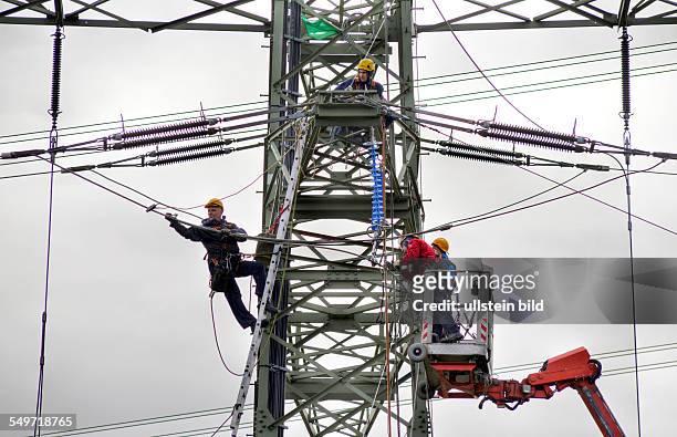 In order of the company RWE, workers on a hogh-voltage mast of RWE AG