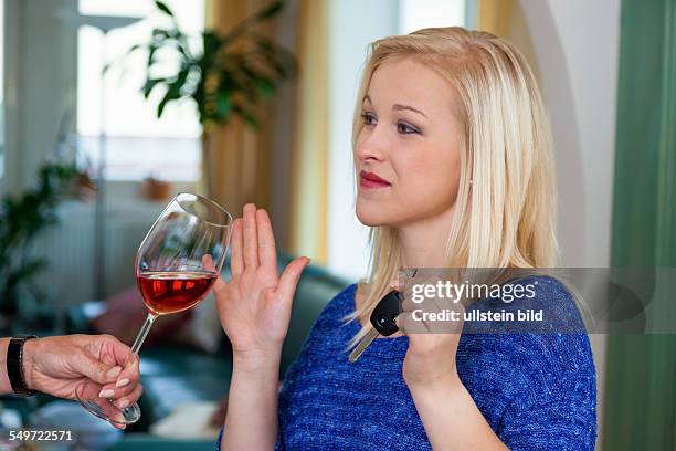 Eine junge Frau mit Autoschlüssel verweigert ein Glas Wein. Don't drink and drive