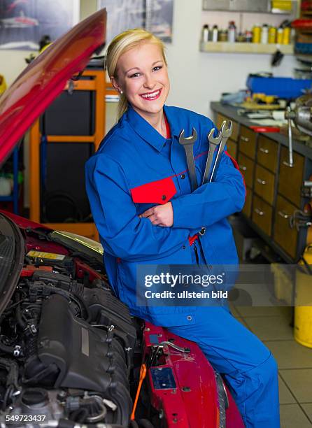 Eine junge Frau als Mechaniker in einer Autowerkstatt. Seltene Berufe für Frauen. Auto wird in Werkstatt repariert