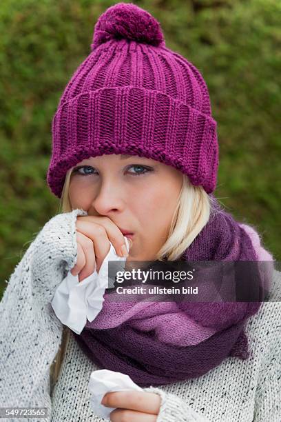 Eine junge Frau hat Schnupfen und ist erkältet. Herbstzeit ist Zeit für Grippe, Schnupfen und Erkältung