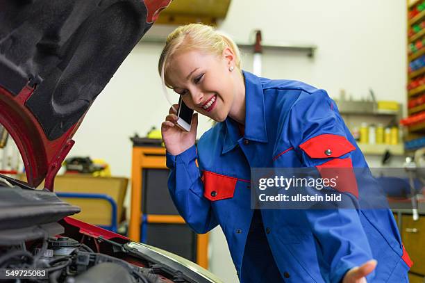 Eine junge Frau als Mechaniker in einer Autowerkstatt. Seltene Berufe für Frauen. Auto wird in Werkstatt repariert