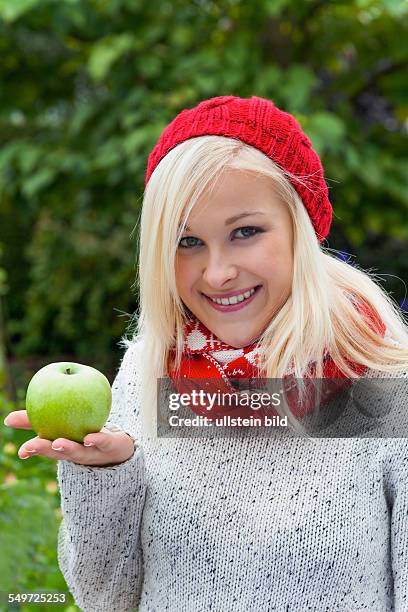 Eine junge Frau mit einem Apfel. Obst und Gemüse sind die richtigen Vitamine für einen kühlen Herbst oder Winter