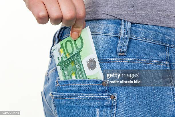 Die Hand einer jungen Frau zieht einen Euro-Geldschein aus der Tasche ihrer Jeans