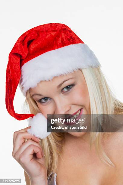 Eine junge Frau mit der Mütze eines Weihnachtsmannes. Weihnachtsfrau zu Weihnachten vor weißem Hintergrund.