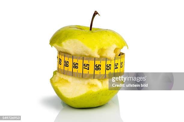 Apfel mit einem Maßband. Symbolfoto für Diät und gesunde, vitaminreiche Ernährung.