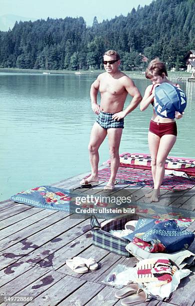 Badegäste an einem See, Junge bläst einen Nivea Wasserball auf