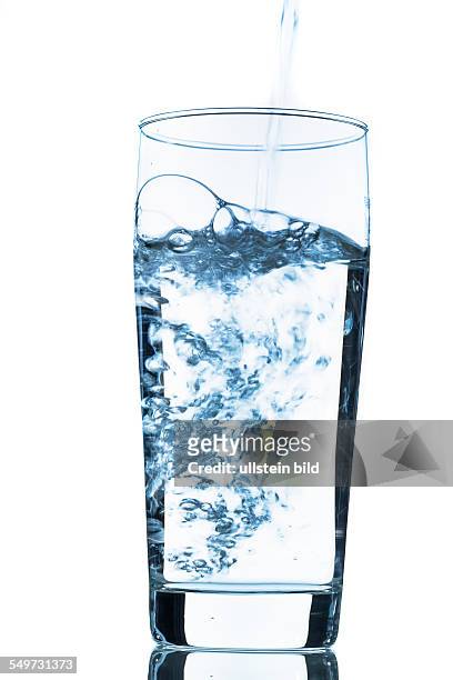 Wasser wird in ein Glas gegossen, Symbolfoto für Trinkwasser, Frische, Bedarf und Verbrauch