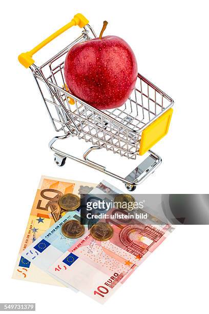 Ein Apfel liegt in einem Einkaufswagen. Symbolfoto für den Einkauf von gesunden, vitaminreichen Lebensmitteln.