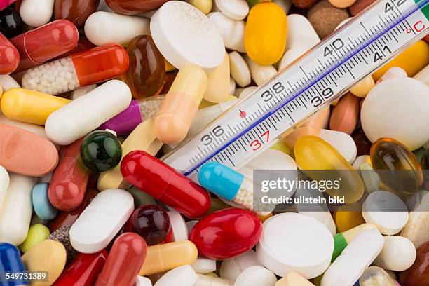 Fieberthermometer und Tabletten, Symbolfoto für Krankheit und Medikation