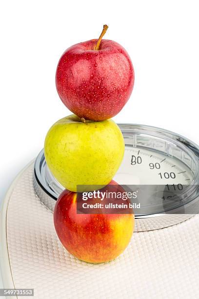 Mehrere Äpfel auf einer Waage für Personen. Symbolfoto für Diät und gesunde, vitaminreiche Ernährung.