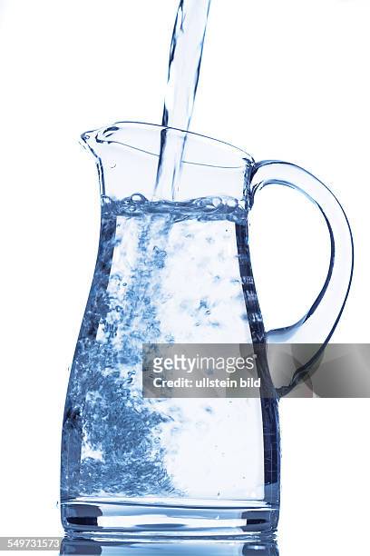 Wasser in eine Karaffe gießen, Symbolfoto für Trinkwasser, Erfrischung, Bedarf und Verbrauch