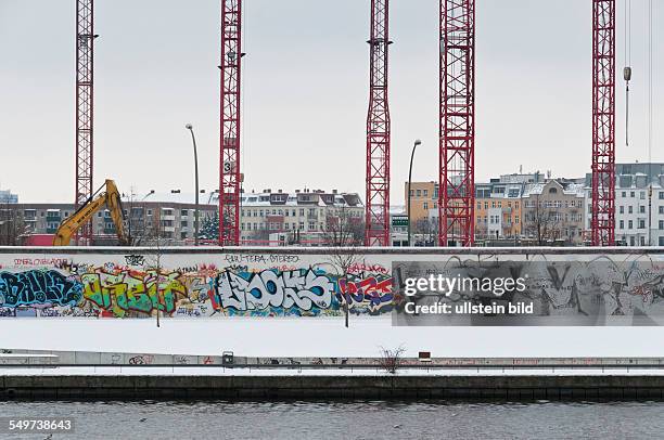 Baukräne hinter der Rückseite der East Side Gallery an der Mühlenstraße in Berlin-Friedrichshain. Auf dem Gelände werden Büro-, Hotel- und...