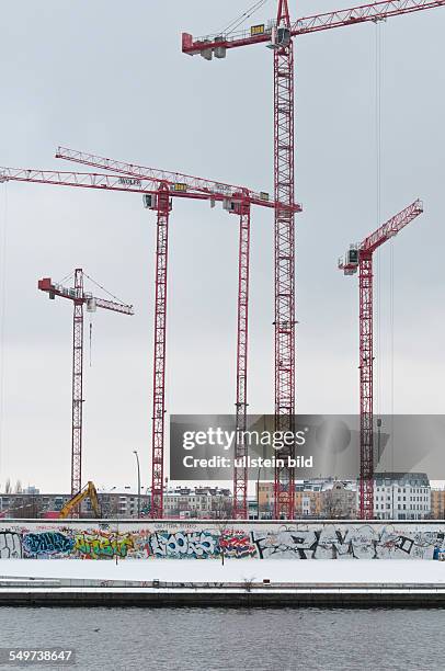 Baukräne hinter der Rückseite der East Side Gallery an der Mühlenstraße in Berlin-Friedrichshain. Auf dem Gelände werden Büro-, Hotel- und...