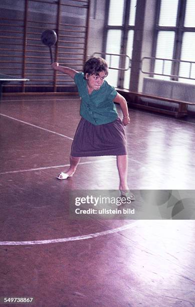 Ca. 1958, Frau beim Wurf eines Schleuderball in einer Turnhalle
