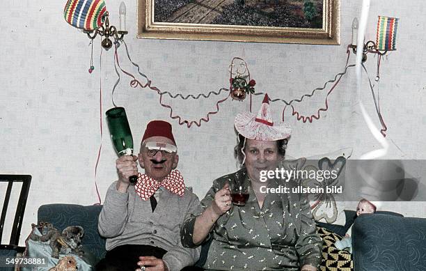 Ca. 1958, Party, Karneval, Silvester, kostümiertes Paar auf dem Sofa