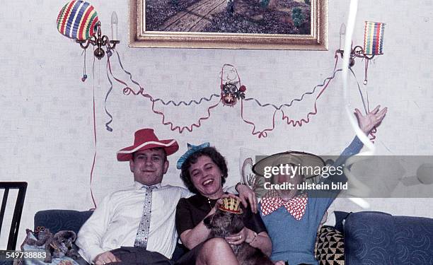 Ca. 1958, Party, Karneval, Silvester, kostümierte Familie auf dem Sofa