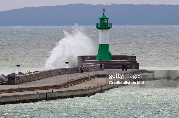 Einige Touristen beobachten eine tosende Welle am Leuchtturm in Sassnitz. In der Hafenstadt au der Insel Ruegen sind 10 Grad und 24 kn Wind aus Ost....