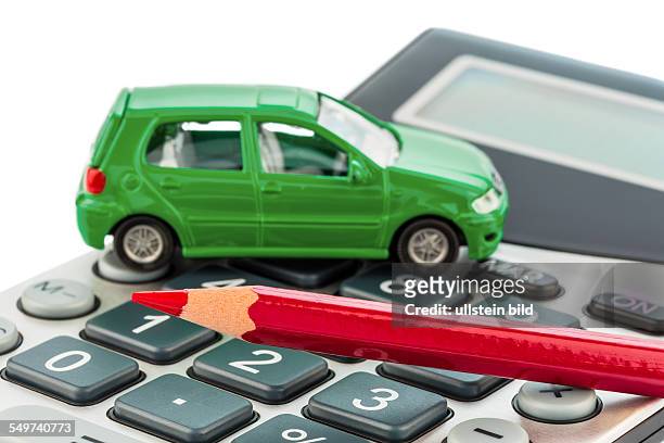 Ein Auto und ein roter Stift liegt auf einem Taschenrechner. Kosten für Benzin, Abnutzung und Versicherung. Autokosten werden durch Pendlerpauschale...