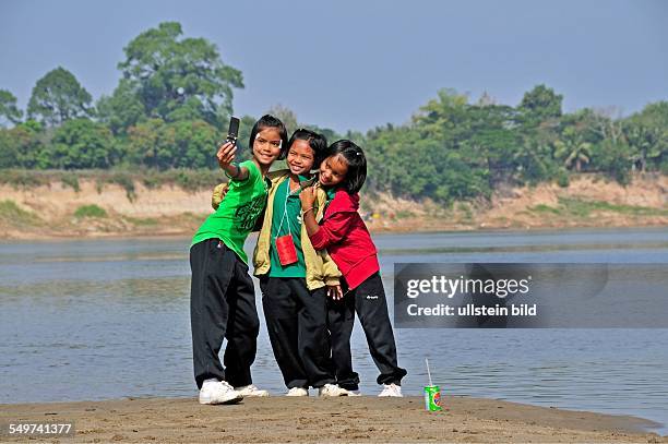 Drei Mädchen fotografieren sich mit dem Handy, Mekong, Nong Khai, Thailand