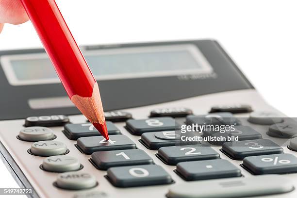 Ein roter Stift liegt auf einem Taschenrechner. Sparen bei Kosten, Ausgaben und Budget wegen schlechter Konjunktur