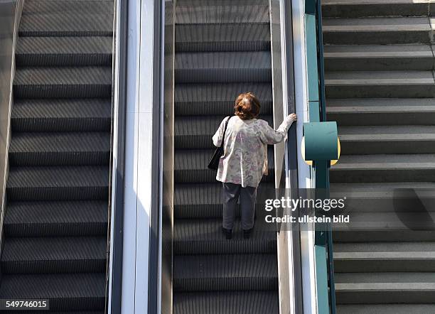 Rolltreppe, Frau. Schlossstrasse, Steglitz, Berlin, Deutschland / Schloßstraße