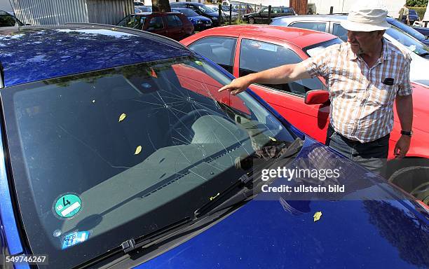 Parkplatzvermieter Martin Mundt zeigt auf seinem Parkplatz in Schaprode ein durch Hagel beschaedigtes Auto eines Hiddenseeurlaubers.